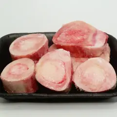 Os à moelle pour chien, crus et congelés, présentés dans un plateau noir. Parfaits pour une alimentation naturelle ou une friandise.
