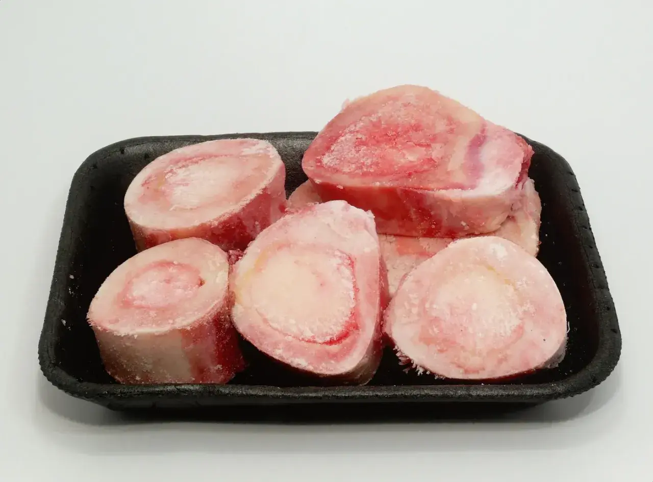Os à moelle pour chien, crus et congelés, présentés dans un plateau noir. Parfaits pour une alimentation naturelle ou une friandise.